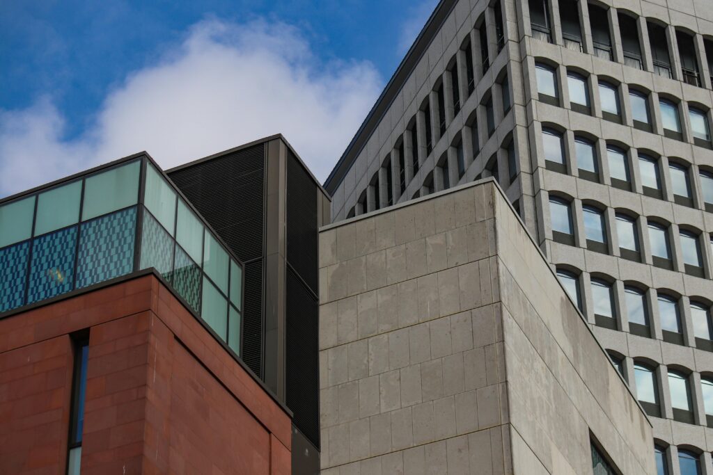 A striking view of modern architecture against a clear blue sky, showcasing geometric forms. safe real estate investment
